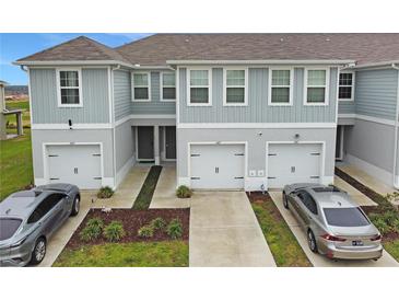 Charming townhomes featuring well-maintained lawns, gray siding, and convenient attached one-car garages at 345 Sedgewick Dr, Davenport, FL 33837