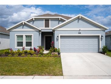Charming one-story home with a two-car garage, manicured lawn, and beautiful landscaping at 4211 Little Owl Ln, Kissimmee, FL 34746