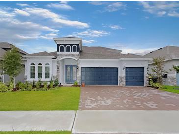 Beautiful one story home featuring a three-car garage, well-manicured lawn, and stone accents at 4507 Lions Gate Ave, Clermont, FL 34711
