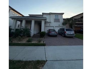 Charming two-story home with a well-maintained lawn, two-car garage, and brick paved driveway at 8289 Topsail Pl, Winter Garden, FL 34787