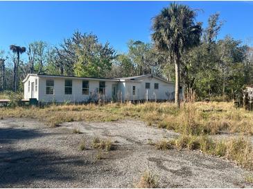 Single-story home with a large front yard and mature trees at 953 Baron Rd, Orlando, FL 32828