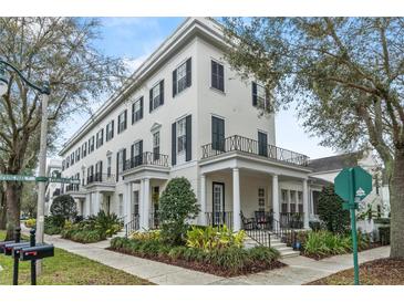 Elegant three-story townhome featuring black shutters and a charming front porch at 1154 Celebration Ave, Celebration, FL 34747