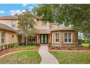Charming home with a beautiful stone facade, mature landscaping and a welcoming brick pathway to the front door at 1686 Shadowmoss Cir, Lake Mary, FL 32746