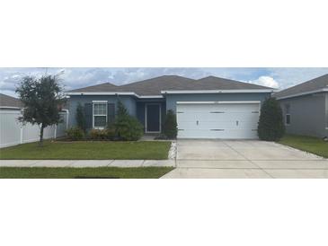 Charming single-story home with a well-maintained lawn, mature trees, and a two-car garage at 1707 Ambar Ct, Winter Haven, FL 33881