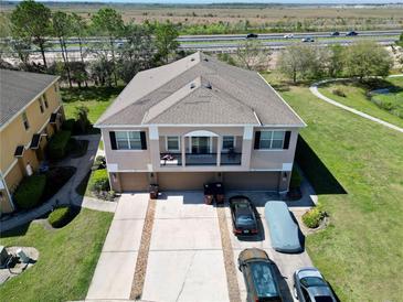 Expansive aerial view of a home featuring a spacious driveway, manicured lawn, and easy access to nearby roadways at 2120 Betsy Ross Ln, St Cloud, FL 34769