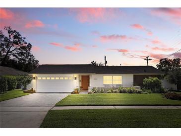 Charming single-story home featuring a well-manicured lawn and a freshly painted white brick facade under a colorful sky at 2654 Derbyshire Rd, Maitland, FL 32751