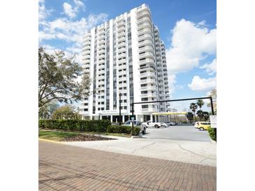 Exterior of a condominium building with white balconies against a blue sky with puffy white clouds at 400 E Colonial Dr # 1504, Orlando, FL 32803