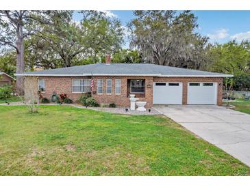 Charming brick home featuring a well-maintained lawn, double garage, and inviting facade at 4884 Meadow Dr, St Cloud, FL 34772