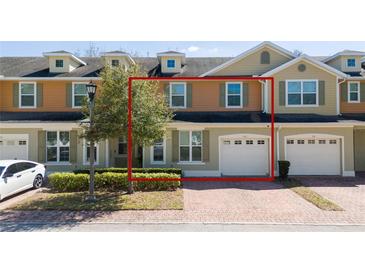 Charming townhome with a brick driveway and a one-car garage at 521 Pacito Way, St Cloud, FL 34769