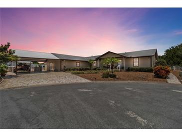 Beautiful single-story home featuring a metal roof, circular driveway, and well-maintained landscaping at 534 Minnow Ct, Kenansville, FL 34739