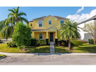 Bright yellow two-story home featuring a well-manicured lawn and mature palm trees at 1000 Seburn Rd, Apopka, FL 32703