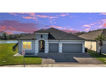Charming single-Gathering home with a two-car garage, paver driveway, and manicured front lawn at 1130 Pando Loop, Orlando, FL 32824