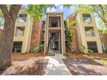 Condo exterior with brick and siding, balconies, stairwell, and surrounding trees at 2210 Yankee Pl # 334, Orlando, FL 32839