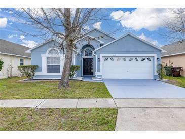 Charming blue single Gathering home with a well-manicured lawn and a two-car garage at 4614 Falcon Ave, Kissimmee, FL 34746