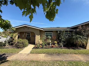 Charming single-story home with lush front yard landscaping, complemented by a walkway leading to a covered entryway at 502 Polaris Loop # 110, Casselberry, FL 32707