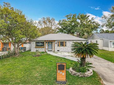Charming single-story home featuring a manicured lawn, stone facade, and inviting front entrance at 521 Florida Ave, St Cloud, FL 34769