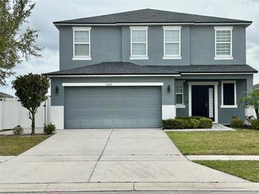 Charming two-story home with a well-manicured lawn and a spacious driveway leading to a two-car garage at 5640 Silver Thistle Ln, St Cloud, FL 34772