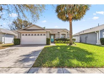 Charming single-story home featuring a well-maintained lawn and a light blue front door at 7706 Water Oak Ct, Kissimmee, FL 34747
