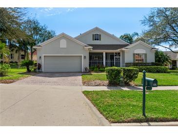 Charming one-story home featuring well-manicured lawn, brick driveway, and a welcoming front porch at 993 Everest, Clermont, FL 34711