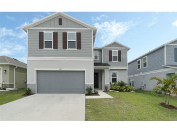 Charming two-story home with a well-maintained lawn and a two-car garage at 1143 Seedorf Dr, Winter Haven, FL 33881