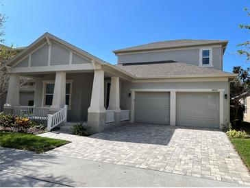Charming two-story home with neutral paint, a two-car garage, and a brick paver driveway at 14419 Magnolia Ridge Loop, Winter Garden, FL 34787