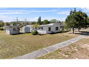 An exterior view of a white house with a well-maintained yard and lush greenery at 425 S 12Th St, Lake Wales, FL 33853
