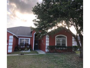 Charming home with a well-maintained front yard, mature tree, and classic architectural details at 516 Brentford Ct, Kissimmee, FL 34758