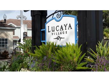 Lucaya Village sign surrounded by lush landscaping and colorful flowers at 5364 Diplomat Ct # 106, Kissimmee, FL 34746