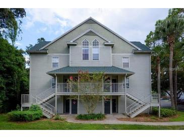 Inviting two-story condo with dual entry stairs, verdant landscaping, and an attractive, neutral-toned facade at 5968 Westgate Dr # 101, Orlando, FL 32835