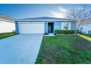 Charming single-story home with a well-manicured front lawn and a two-car garage in a residential neighborhood at 751 Jefferson St, Davenport, FL 33837