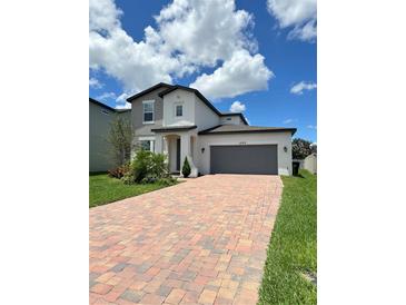 Two-story home with brick driveway, a two-car garage and manicured landscaping at 1220 Hilltop Pl # 1220, St Cloud, FL 34772
