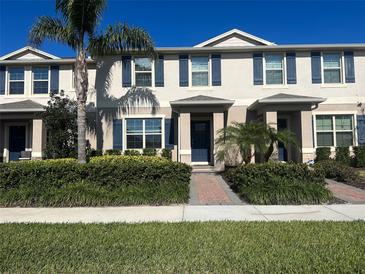 Inviting townhome with blue shutters, a tidy landscaped yard, and a welcoming entryway at 16180 Arbor Crest Aly, Winter Garden, FL 34787