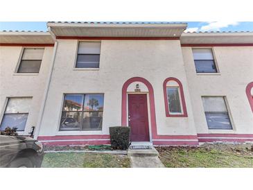 Charming townhome with a red door, cream stucco and red trim plus nicely kept front lawn area at 1631 Little Falls Cir # 92, Orlando, FL 32807