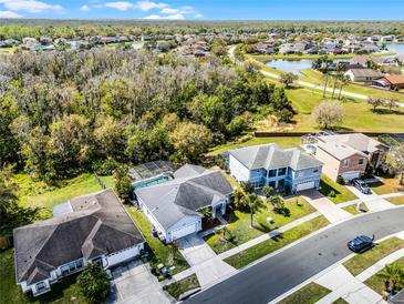 An aerial view showcases a neighborhood with lush greenery, ponds and well-maintained homes, some with screened in pools at 2539 Jasmine Trace Dr, Kissimmee, FL 34758