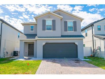 Charming two-story home with a paved driveway, two car garage and manicured lawn at 2804 Alpine Meadow Ln, Kissimmee, FL 34744
