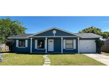 Charming single-story home features a blue exterior, white trim, and a well-maintained lawn at 4861 Haines Circle, Orlando, FL 32822