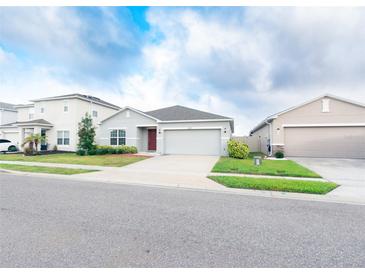 Charming single-story home with a well-maintained lawn and two-car garage at 551 Meadow Bend Dr, Davenport, FL 33837