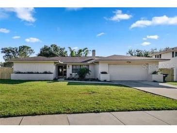 Charming one-story home with a well-manicured lawn and a two car garage at 8452 Sandberry Blvd, Orlando, FL 32819