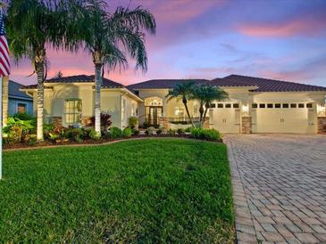 Stunning home with lush landscaping, paver driveway and tile roof, set against a beautiful twilight sky at 1233 Cambria Bnd, Kissimmee, FL 34759