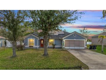 Charming home with a well-maintained lawn, complemented by mature trees and a two car garage at 1437 Swift Ct, Kissimmee, FL 34759