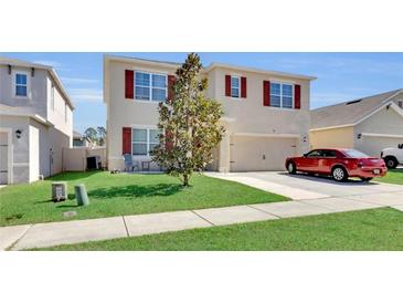 Charming two-story home with well-kept lawn, red shutters, and a two-car garage at 260 Willow Bend Dr, Davenport, FL 33897
