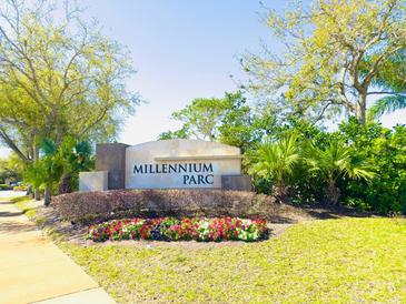 Beautiful monument sign at Millennium Parc surrounded by flowers, trees, and lush landscaping at 3655 Zuma Way, Orlando, FL 32839