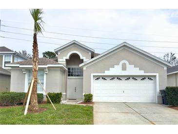 Charming single-story home featuring a well-manicured lawn and a two-car garage at 8204 Fan Palm Way, Kissimmee, FL 34747