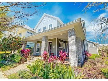 Charming two-story home with a welcoming front porch and colorful landscaping at 13041 Gabor Ave, Orlando, FL 32827