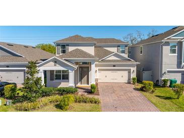Charming two-story home with well-manicured landscaping and a brick driveway at 14321 Wabasso Loop, Winter Garden, FL 34787