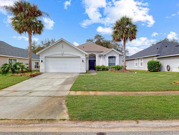 Charming single story home with two-car garage, lush lawn, and palm trees in a desirable neighborhood at 1718 Golfview Dr, Kissimmee, FL 34746