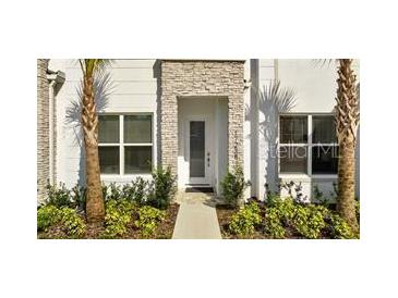Charming two-story home featuring stacked stone accents and manicured landscaping at 17238 Blessing Dr, Clermont, FL 34714