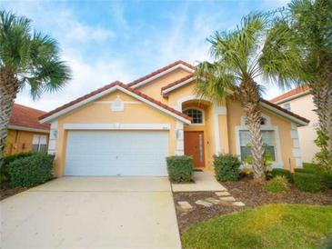 Charming single-Gathering home featuring a well-maintained front lawn and attached two-car garage at 215 Cordova Ave, Davenport, FL 33897