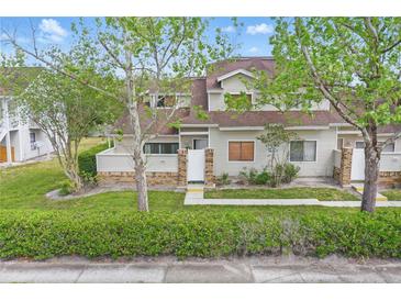 Charming townhouse featuring neutral siding, brick accents, lush landscaping, and a welcoming walkway to the entrance at 3203 Rio Grande Trl, Kissimmee, FL 34741