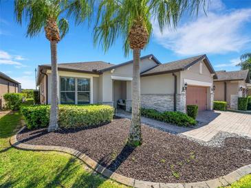 Charming home featuring manicured landscaping, stone accents, and a brick driveway at 688 Cordoba Dr, Davenport, FL 33837